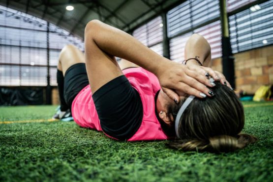 Female soccer player sad after the match on a soccer field